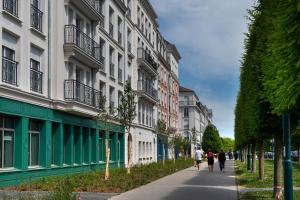 um grupo de pessoas andando por uma rua ao lado de edifícios em DOMITYS SARIA em Serris