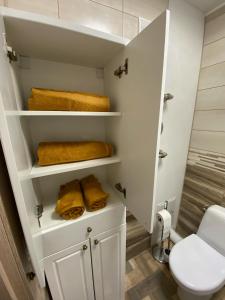 a bathroom with a toilet and towels on shelves at Прелестное жильё у Akropole, бесплатная парковка. in Rīga