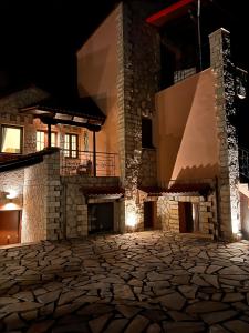 een stenen binnenplaats van een huis 's nachts bij Ski Suites - Family Maisonette Kalavryta in Kalavrita