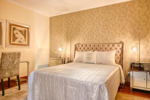 Canhas的住宿－Villa Mendonca, a Home in Madeira，一间卧室配有一张大床和一把椅子