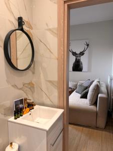 een badkamer met een wastafel, een bed en een spiegel bij Ski Suites - Family Maisonette Kalavryta in Kalavrita +70 foto's