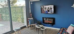 a living room with a blue wall with a fireplace at VERDVILLAGE in Valença