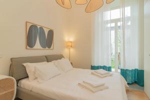 een wit bed in een kamer met een raam bij Liberdade Garden & Indoor Pool by LovelyStay in Lissabon