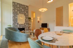een woonkamer met een tafel en stoelen bij Liberdade Garden & Indoor Pool by LovelyStay in Lissabon