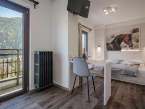 Schlafzimmer mit einem Schreibtisch, einem Bett und einem Fenster in der Unterkunft Hotel Garnì Alta Valle in Ponte di Legno