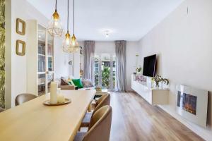 a dining room and living room with a table and chairs at MÁlaga Playa in Málaga