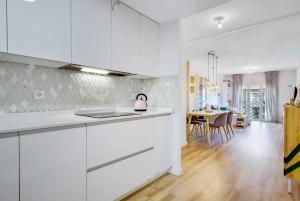 a kitchen with white cabinets and a dining room at MÁlaga Playa in Málaga