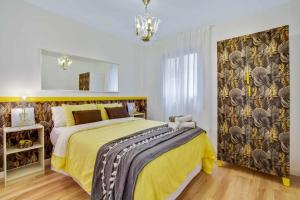 sypialnia z dużym łóżkiem i żółtym kocem w obiekcie MÁlaga Playa w Maladze