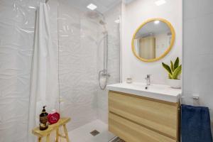 a bathroom with a sink and a shower with a mirror at MÁlaga Playa in Málaga