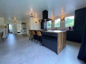a kitchen with a island with a counter and chairs at Bandrew in Stoumont
