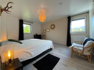 a bedroom with a white bed and a chair at Bandrew in Stoumont