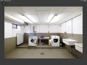 a bathroom with a washing machine and a sink at Schlafhaus Dünenweg 16 in Heringsdorf