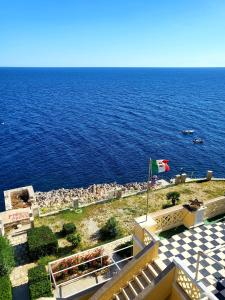 vistas al océano desde un edificio con bandera en Miramare Vacanze Apartment, en Santa Cesarea Terme