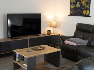 a living room with a couch and a television at Ferienwohnung Gute Zeit - Apartment 1 in Bleialf