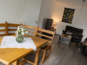 a living room with a dining room table with a vase of flowers at Ferienwohnung Gute Zeit - Apartment 1 in Bleialf