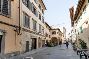 uma rua com edifícios e pessoas andando por uma rua em Mamo Florence - Guya Apartment em Florença