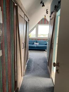 einen Flur mit blauer Couch in einem Zimmer in der Unterkunft Urban Nature13 in Grömitz