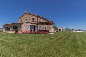 a stone house on a field with a large yard at Villa Aga - Homelike Villas in Cingoli