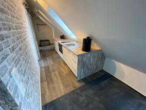 an attic kitchen with a sink and a brick wall at Meerblick 14 in Grömitz