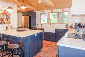 a kitchen with blue cabinets and white counter tops at Lake Winni Cottage in Moultonborough +16 photos
