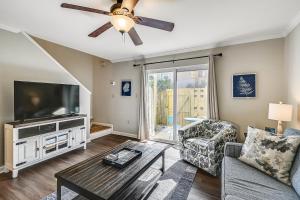 ein Wohnzimmer mit einem Flachbild-TV und einem Sofa in der Unterkunft 1BR Townhouse on Okaloosa Island - 5 Min Walk to Beach! Near Restos! in Fort Walton Beach