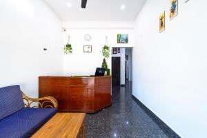 a living room with a couch and a desk at RAINBOW RESIDENCY ECR in Auroville