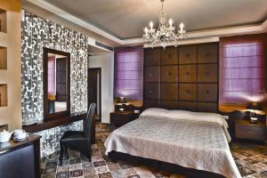 a bedroom with a bed and a chandelier at Phaidon Hotel & Spa in Florina