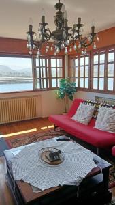 sala de estar con sofá rojo y lámpara de araña en Casa Tirador en San Martin del Mar