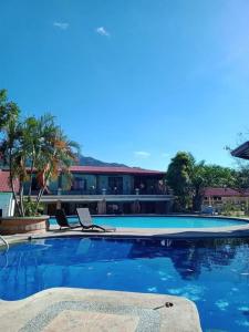 - une piscine avec 2 chaises en face d'un bâtiment dans l'établissement La Vista Pansol Resort Complex by RedDoorz, à Pansol
