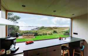 uma cozinha com uma grande janela com vista para um lago em Stunning Home In Farsund With Kitchen em Farsund