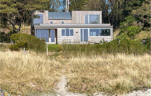una casa sentada en la parte superior de un campo cubierto de hierba en Stunning Home In Farsund With Kitchen en Farsund