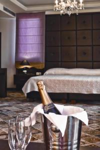 a bottle of champagne in a bucket in a bedroom at Phaidon Hotel & Spa in Florina +9 photos