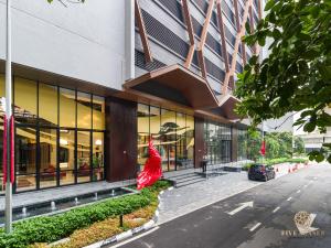 una mujer con un vestido rojo parada fuera de un edificio en Scarletz Suites Kuala Lumpur, Five Senses, en Kuala Lumpur