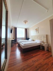 1 dormitorio con 2 camas y un espejo grande en R&B Hotel en Berlín
