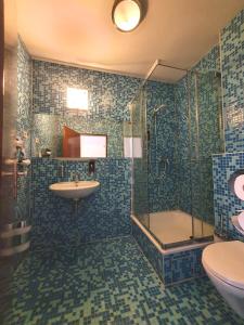 ein Bad mit einem Waschbecken, einer Dusche und einem WC in der Unterkunft R&B Hotel in Berlin