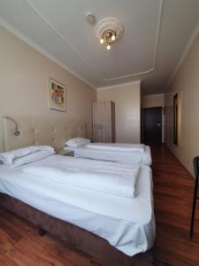 two large beds in a room with wooden floors at R&B Hotel in Berlin +7 photos
