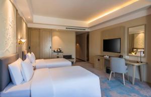 um quarto de hotel com duas camas e uma televisão em Aber Khamis Mushait em Khamis Mushayt