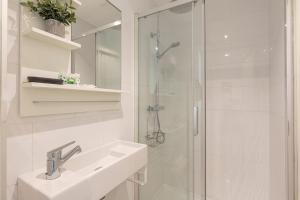 a white bathroom with a sink and a shower at AG Apartments in Barcelona