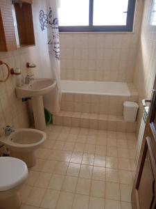 y baño con bañera, aseo y lavamanos. en Apartment Degobbis, en Rovinj