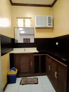 eine Küche mit einer Spüle und einer Mikrowelle in der Unterkunft La Vista Pansol Resort Complex by RedDoorz in Pansol