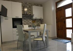 een keuken met een tafel en stoelen in een kamer bij Sognando nel borgo in Rocca Imperiale