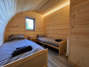 a room with two beds in a log cabin at Outdoor Inns - Star at Lidgate in Newmarket