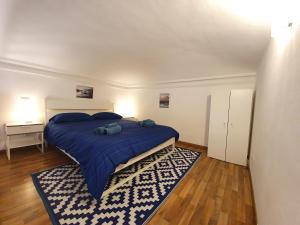 um quarto com uma cama com um cobertor azul e um tapete em Casa Marsili - Luxury Apartment em Turim