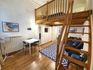 um quarto com uma cama alta, uma mesa e uma secretária em Casa Marsili - Luxury Apartment em Turim