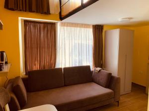 salon z kanapą i dużym oknem w obiekcie Auto Tana Guest House w Tiranie