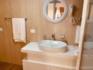 W łazience znajduje się umywalka i lustro. w obiekcie Auto Tana Guest House w Tiranie