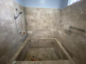 a bathroom with a tub with a shower at La Vista Pansol Resort Complex by RedDoorz in Pansol