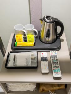 a table with a tea kettle and remote controls on it at HOTEL LENITH Seomyeon in Busan