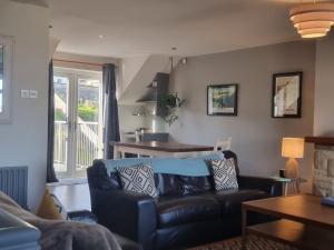 a living room with a couch and a table at Harbour View Townhouse in Portrush