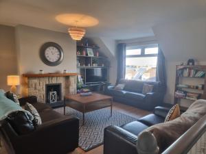 a living room with a couch and a fireplace at Harbour View Townhouse in Portrush